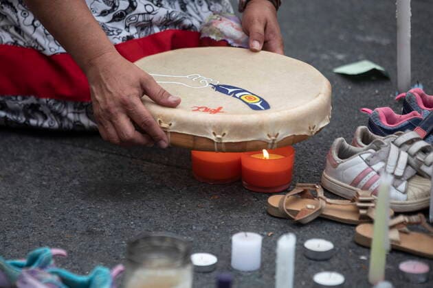 July 1, 2021, Toronto, on, Canada: A drummer dries the skin of her drum on candles during a Cancel Canada Day rally in Toronto, on Thursday, July 1, 2021 to honour former residential school victims. Toronto Canada  - ZUMAc35_ 20210701_zaf_c35_268 Copyright: xChrisxYoungx
