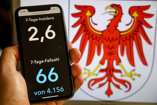 Coronavirus in Deutschland - Covid-19-Dashboard des Robert Koch-Institut DEU, Deutschland, Brandenburg, 02.07.2021: Die 7-Tage-Inzidenz für das Bundesland (Fälle letzte 7 Tage 100.000 EW) wird auf einem iPhone angezeigt, im Hintergrund das Landeswappen