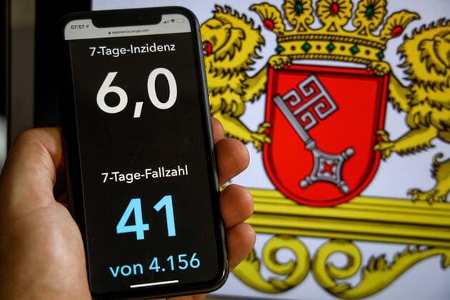 Coronavirus in Deutschland - Covid-19-Dashboard des Robert Koch-Institut DEU, Deutschland, Bremen, 02.07.2021: Die 7-Tage-Inzidenz für das Bundesland (Fälle letzte 7 Tage 100.000 EW) wird auf einem iPhone angezeigt, im Hintergrund das Landeswappen