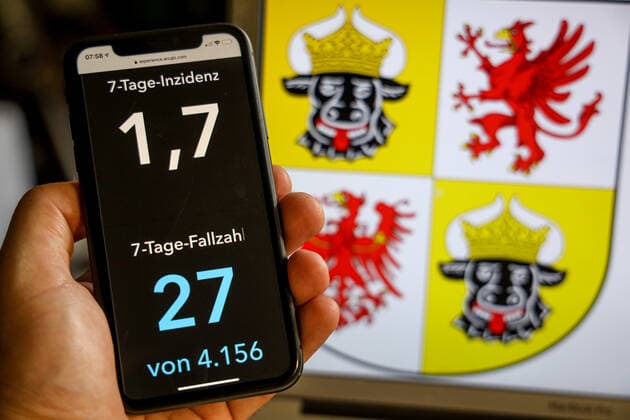 Coronavirus in Deutschland - Covid-19-Dashboard des Robert Koch-Institut DEU, Deutschland, Mecklenburg-Vorpommern, 02.07.2021: Die 7-Tage-Inzidenz für das Bundesland (Fälle letzte 7 Tage 100.000 EW) wird auf einem iPhone angezeigt, im Hintergrund das Landeswappen