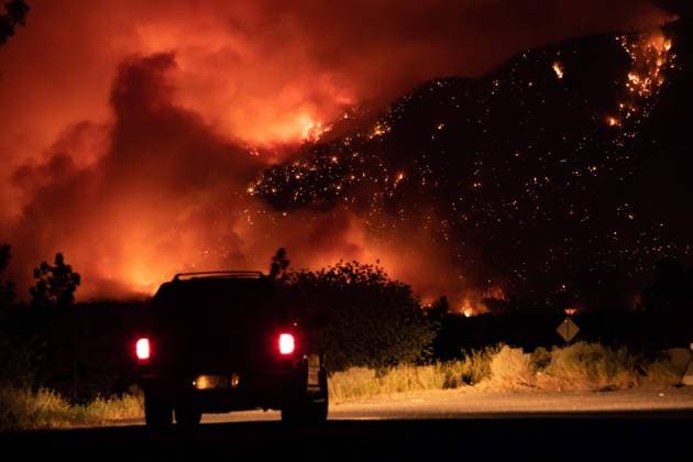 IMAGO Nature: Unsere Erde, Klimawandel, Waldbrände July 1, 2021, Lytton, BC, Canada: A motorist watches from a pullout on the Trans-Canada Highway as a wildfire burns on the side of a mountain in Lytton, B.C., Thursday, July 1, 2021. Lytton Canada  - ZUMAc35_ 20210701_zaf_c35_318 Copyright: xDarrylxDyckx