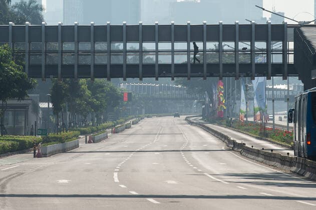 (210703) -- JAKARTA, July 3, 2021 -- A man walks on the pedestrian bridge over the closed Sudirman Street during the implementation of emergency community activity restrictions in Jakarta, Indonesia, July 3, 2021. The Indonesian government has officially imposed emergency community activity restrictions from July 3 to July 20 amid surging COVID-19 cases, specifically in the islands of Java and Bali. ) INDONESIA-JAKARTA-COVID-19-EMERGENCY RESTRICTIONS VerixSanovri 