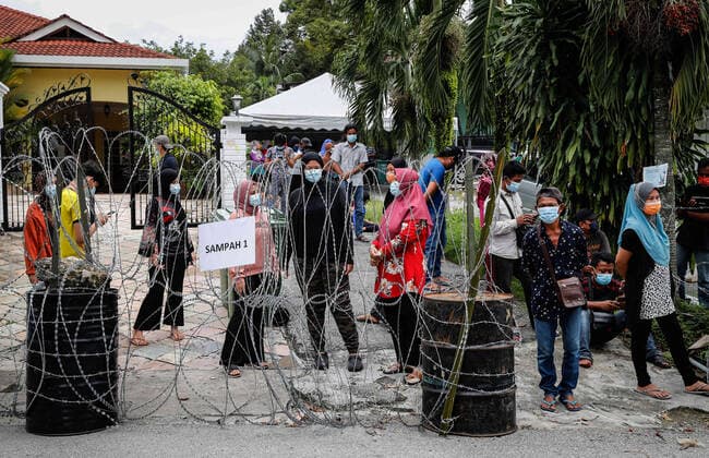 July 3, 2021, Kuala Lumpur, Malaysia: Residents wearing masks stand behind the barbwire as they wait for the Covid-19 swab test at the Segambut Dalam housing area which was placed under the enhanced movement control order (EMCO) due to surge in the number of COVID-19 daily cases recorded..Malaysia government starts to further tighten the movement control and imposes lockdown in state of Selangor and parts of Kuala Lumpur, due to the daily high number of coronavirus infections cases reported. Kuala Lumpur Malaysia - ZUMAs197 20210703_zaa_s197_005 Copyright: xWongxFokxLoyx
