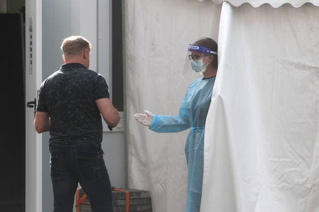 Mitarbeiterin eines Corona Testzentrums in der Innenstadt von Heidelberg spricht mit einem Kunden, der einen kostenlosen Bürgertest vornehmen lassen möchte, Baden Württemberg, Deutschland