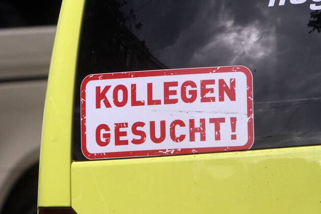 Aufkleber mit Aufschrift Kollegen gesucht klebt am Rückfenster eines Krankentransportwagen s in der Innenstadt von Heidelberg, Baden Württemberg, Deutschland