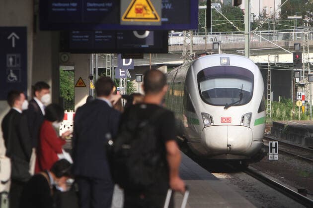 Nach den Lockerungsmaßnahmen und den aufgehobenen Reisebeschränkungen während der Coronaviruskrise nutzen wieder wesentlich mehr Menschen die Züge im Fernverkehr der DB Deutsche n Bahn: Masken tragende Fahrgäste in Anzügen erwarten die Ankunft eines ICE der DB Deutsche Bahn im Hauptbahnhof von Heidelberg, Baden Württemberg, Deutschland