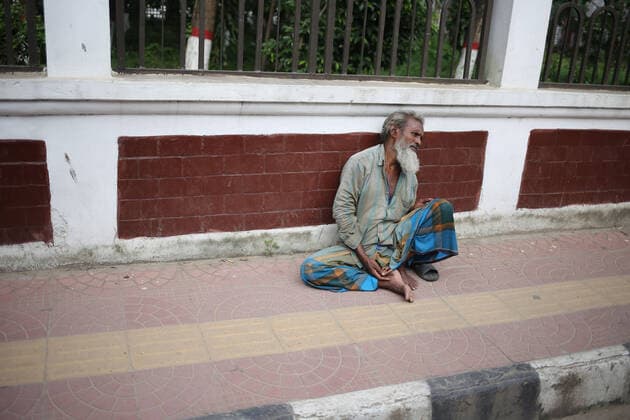 July 6, 2021, Dhaka, Bangladesh: A homeless man is sitting on the empty street side during the lockdown cause by COVID-19. Dhaka Bangladesh - ZUMAh355 20210706_zip_h355_010 Copyright: xMd.xRakibulxHasanx