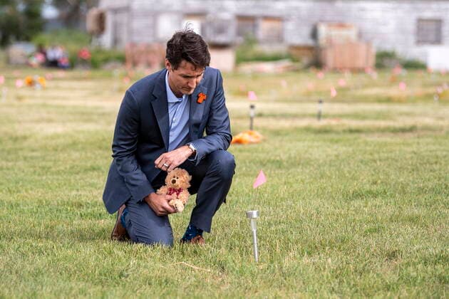 July 6, 2021, Cowessess First Nation, SK, Canada: Prime Minister Justin Trudeau lays a teddy bear at a small flag in a field prior to a ceremony at the site of a former residential school where, last month, ground-penetrating radar detected a potential 751 unmarked graves, in Cowessess First Nation, Sask., Tuesday, July 6, 2021. Cowessess First Nation Canada - ZUMAc35_ 20210706_zaf_c35_089 Copyright: xLiamxRichardsx