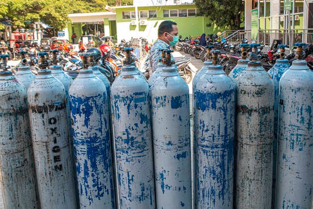 Increased Oxygen Usage Residents walk near canisters filled with oxygen before being distributed to Covid-19 patient rooms at the Covid-19 referral hospital in Palu, Central Sulawesi, Indonesia, Wednesday 7 July 2021. The use of oxygen has increased along with the increase in Covid-19 patients being hospitalized this. Although the number of patients infected with Covid-19 has increased in Palu, the availability of oxygen is sufficient and there is no shortage.  Copyright: xOpanxBustanx xOpnxImagesx