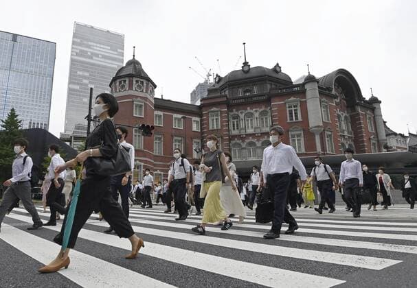 Scene from Tokyo amid coronavirus pandemic People wearing face masks walk in front of Tokyo Station in the Japanese capital on July 8, 2021, amid the coronavirus pandemic. 