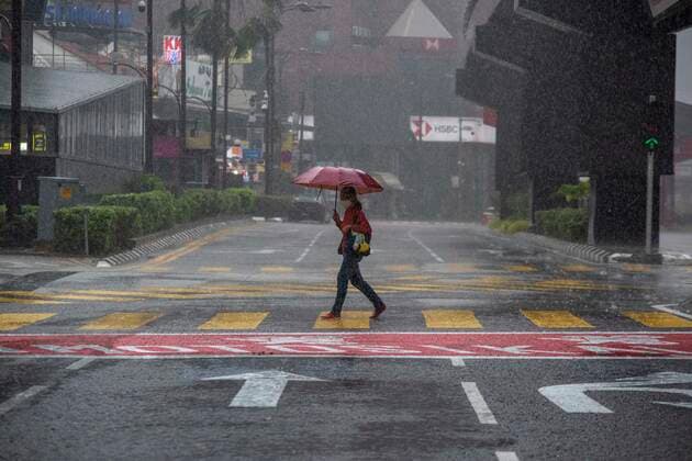 (210708) -- KUALA LUMPUR, July 8, 2021 -- A woman wearing a face mask walks in the rain in Kuala Lumpur, Malaysia, July 8, 2021. Malaysia recorded a fresh high of 135 single-day death toll from COVID-19 on Thursday, bringing the total deaths to 5,903, according to the health ministry. Another 8,868 new infections were reported in the second-highest single-day tally since the outbreak, bringing the national total to 808,658. (Photo by Xinhua) MALAYSIA-KUALA LUMPUR-COVID-19-CASES ChongxVoonxChung
