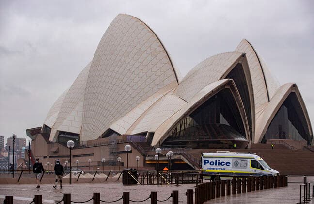 (210709) -- SYDNEY, July 9, 2021 -- A police vehicle is seen in front of Sydney Opera House in Sydney, Australia, on July 9, 2021. Australia s state of New South Wales Friday announced to further tighten restrictions on Greater Sydney and surrounding areas as the state continues to see a surge in daily increase of COVID-19 cases. ) AUSTRALIA-SYDNEY-COVID-19-RESTRICTIONS-TIGHTENING BaixXuefei 