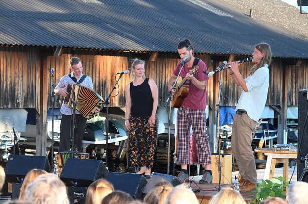 Konzert der Peter Mayer Hofkapelle, In der Bootswerft Frauscher in Gmunden, im Rahmen der Salzkammergut Festwochen Gmunden, am 09.07.21. Das Bild zeigt v.l.n.r.: Andreas Jamnik, Steirische Harmonika und Gesang, Nora Mayer, Gesang und Perkussion, Peter Mayer, Gitarre und Gesang, Michl Dumfarth, Klarinette und Gesang 2021 - Konzert der Peter Mayer Hofkapelle, In der Bootswerft Frauscher in Gmunden, im Rahmen der Salzkammergut Festwochen Gmunden, am 09.07.21