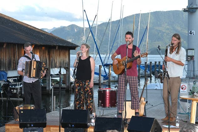 Konzert der Peter Mayer Hofkapelle, In der Bootswerft Frauscher in Gmunden, im Rahmen der Salzkammergut Festwochen Gmunden, am 09.07.21. Das Bild zeigt v.l.n.r.: Andreas Jamnik, Steirische Harmonika und Gesang, Nora Mayer, Gesang und Perkussion, Peter Mayer, Gitarre und Gesang, Michl Dumfarth, Klarinette und Gesang 2021 - Konzert der Peter Mayer Hofkapelle, In der Bootswerft Frauscher in Gmunden, im Rahmen der Salzkammergut Festwochen Gmunden, am 09.07.21