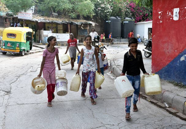NEW DELHI, INDIA ? JULY 10: Children carry water cans to collect drinking water from a tanker in Sanjay camp, Chanakyapuri, on July 10, 2021 in New Delhi, India. The Aam Aadmi Party MLA said Haryana has been supplying about 100 million gallons less water per day, which has led to water crisis in NDMC areas, central, south, and west Delhi. (Photo by Sonu Mehta Hindustan Times ) Water Crisis In Delhi