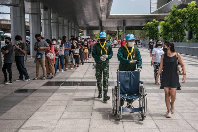 July 11, 2021, Bangkok, Thailand: Volunteer soldiers push a wheelchair while people stand in a line to be vaccinated with AstraZeneca vaccine outside Bang Sue Grand Station during a vaccination against COVID-19 at Bang Sue Grand Station in Bangkok. .Thailand has a record high of 86 new Covid-19 fatalities and 9,539 new cases over the past 24 hours, the Public Health Ministry reported on 11 July 2021. Bangkok Thailand - ZUMAs197 20210711_zaa_s197_075 Copyright: xPeeraponxBoonyakiatx