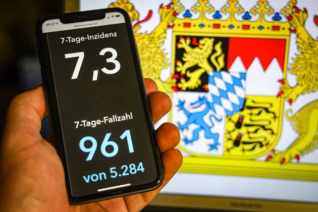 Coronavirus in Deutschland - Covid-19-Dashboard des Robert Koch-Institut DEU, Deutschland, Bayern, 12.07.2021: Die 7-Tage-Inzidenz für das Bundesland (Fälle letzte 7 Tage 100.000 EW) wird auf einem iPhone angezeigt, im Hintergrund das Landeswappen