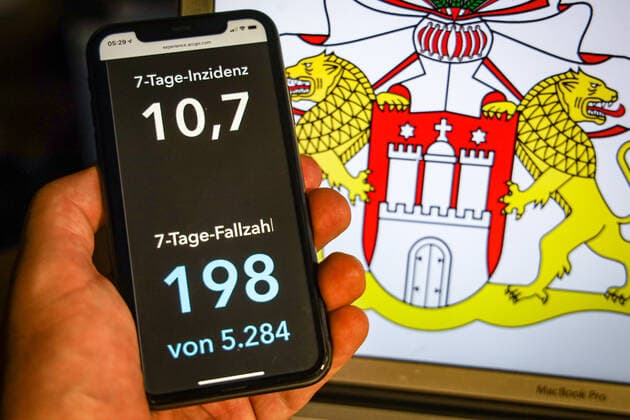 Coronavirus in Deutschland - Covid-19-Dashboard des Robert Koch-Institut DEU, Deutschland, Hamburg, 12.07.2021: Die 7-Tage-Inzidenz für das Bundesland (Fälle letzte 7 Tage 100.000 EW) wird auf einem iPhone angezeigt, im Hintergrund das Landeswappen