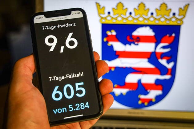 Coronavirus in Deutschland - Covid-19-Dashboard des Robert Koch-Institut DEU, Deutschland, Hessen, 12.07.2021: Die 7-Tage-Inzidenz für das Bundesland (Fälle letzte 7 Tage 100.000 EW) wird auf einem iPhone angezeigt, im Hintergrund das Landeswappen