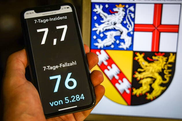 Coronavirus in Deutschland - Covid-19-Dashboard des Robert Koch-Institut DEU, Deutschland, Saarland, 12.07.2021: Die 7-Tage-Inzidenz für das Bundesland (Fälle letzte 7 Tage 100.000 EW) wird auf einem iPhone angezeigt, im Hintergrund das Landeswappen
