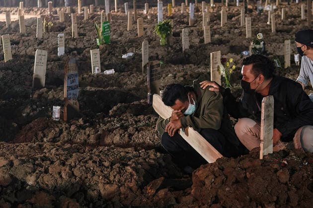 July 11, 2021, Jakarta, Indonesia: Relatives wearing face masks mourn during the burial of coronavirus (COVID-19) victim at Rorotan public cemetery in Jakarta..Indonesia has the highest COVID-19 death toll in South East Asia with 66,464 victims as recorded by the National Disaster Mitigation Agency. Jakarta Indonesia - ZUMAs197 20210711_zaa_s197_580 Copyright: xWisnuxPrasetyox