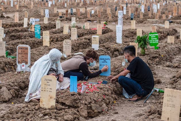 July 11, 2021, Jakarta, Indonesia: Relatives write their surnames on a tombstone at Rorotan public cemetery..Indonesia has the highest COVID-19 death toll in South East Asia with 66,464 victims as recorded by the National Disaster Mitigation Agency. Jakarta Indonesia - ZUMAs197 20210711_zaa_s197_582 Copyright: xWisnuxPrasetyox