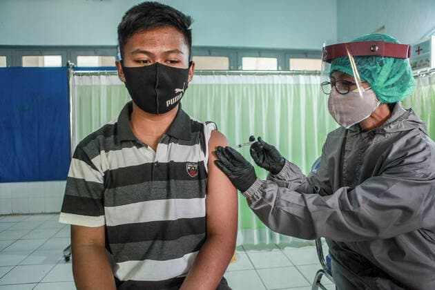 July 14, 2021, Malang, Indonesia: A health worker administers a coronavirus vaccine to a child at Naval Base in Malang..The Indonesian Ministry of Health has started to roll out Phase Three Vaccinations for Vulnerable People, Other General People, and Children aged 12-17 years. Malang Indonesia - ZUMAs197 20210714_zaa_s197_008 Copyright: xBayuxNovantax
