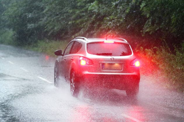 Gefährliche Straßenverhältnisse bei Starkregen. Autos fahren durch plötzliche Starkregenfälle, Gewitter, Sturmböen und schlechter Sicht durch eine teils überflutete Straße Essen Nordrhein-Westfalen Deutschland Überruhr *** Dangerous road conditions during heavy rain Cars driving through a partly flooded road due to sudden heavy rain, thunderstorms, squalls and poor visibility Essen North Rhine Westphalia Germany Überruhr