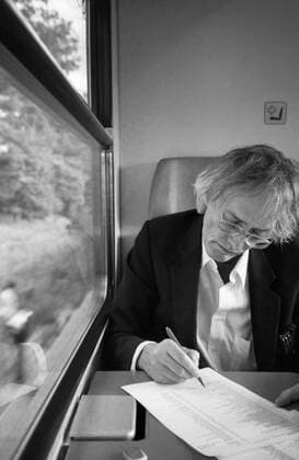 Timm Ulrichs im Zug von Berlin nach Magdeburg und korrigiert Fahnen für den Katalog Der detektorische Blick (NGBK), 19.9.1997. Auf dem Weg zu einer Arbeitsbesprechung wegen seines Entwurfs für die Erdachse auf dem Bahnhofsvorplatz in Magdeburg, die 1999 eingeweiht wurde. Die Zugfahrt nutzte Ulrichs zur Korrektur von Druckfahnen für seinen Katalog bei der NGBK Der detektorische Blick . *** Timm Ulrichs on the train from Berlin to Magdeburg correcting flags for the catalogue Der detektorische Blick NGBK , 19 9 1997 On the way to a meeting about his design for the earth axis on the station forecourt in Magdeburg, which was inaugurated in 1999 Ulrichs used the train journey to correct printed flags for his catalogue at the NGBK Der dete