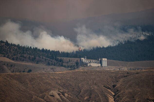 July 16, 2021, Ashcroft, BC, Canada: A tree candles as the Tremont Creek wildfire burns behind the IG Machine & Fibers roofing granule plant, where rock is crushed and coloured and then shipped elsewhere to create roofing shingles, in Ashcroft, B.C., on Friday, July 16, 2021. Ashcroft Canada - ZUMAc35_ 20210716_zaf_c35_073 Copyright: xDarrylxDyckx