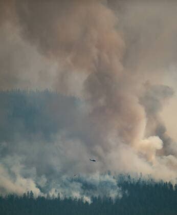 July 16, 2021, Ashcroft, BC, Canada: A helicopter with a water bucket flies past the Tremont Creek wildfire burning on the mountains above Ashcroft, B.C., on Friday, July 16, 2021. Ashcroft Canada  - ZUMAc35_ 20210716_zaf_c35_089 Copyright: xDarrylxDyckx