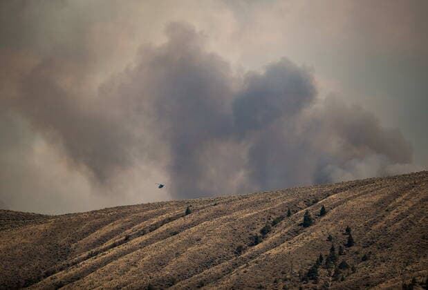 July 16, 2021, Ashcroft, BC, Canada: A helicopter flies behind a ridge as the Tremont Creek wildfire burns on the mountains above Ashcroft, B.C., on Friday, July 16, 2021. Ashcroft Canada  - ZUMAc35_ 20210716_zaf_c35_090 Copyright: xDarrylxDyckx