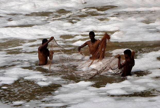 Bilder des Jahres 2021, News 07 Juli News Themen der Woche KW28 News Bilder des Tages NEW DELHI, INDIA - JULY 17: People catching fish in a thick white layer of toxic foam seen over the Yamuna river near the Kalindi Kunj which shows the dangerous water pollution levels. on July 17, 2021 in New Delhi, India. Due to the high level of toxic substances in the water such foams quite often float on the surface of Yamuna river. (Photo by Mohd Zakir Hindustan Times ) White Toxic Foam Seen In Yamuna River Near Kalindi Kunj In Delhi