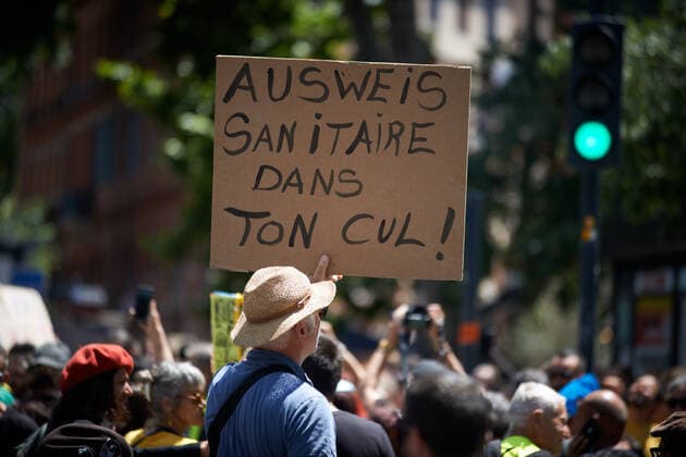 Coronavirus in Frankreich, Impfgegner protestieren in Toulouse Protest Against The Health Pass And The Near Mandatory Vaccination A man holds a cardboardreading Health Ausweiss in your ass... Thousands of people protested in Toulouse and elsewhere in France against the near mandatory vaccination and against the health pass after the Macron s speech on July 12th. Macron announced the health pass will be mandatory for going in public places such as cafes, theates, concerts hall, shops, public transportation (train, bus, tramway), etc. The delay between the first jab and the health pass obtention will be five weeks. But the prohibition for public spaces for non-vaccinated people will go on August 1st. Some say its alike apartheid and 2nd class citizens. Toulouse. France. July 17th 2021 Toulouse Franc  Copyright: xAlainxPittonx