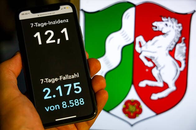 Coronavirus in Deutschland - Covid-19-Dashboard des Robert Koch-Institut DEU, Deutschland, Nordrhein-Westfalen, 19.07.2021: Die 7-Tage-Inzidenz für das Bundesland (Fälle letzte 7 Tage 100.000 EW) wird auf einem iPhone angezeigt, im Hintergrund das Landeswappen