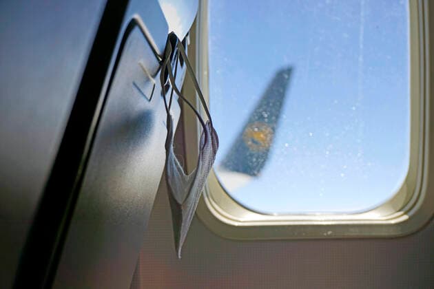 20.07.2021, Reisen und Fliegen in Zeiten der Corona-Pandemie, eine FFP2-Maske hängt an der Lehne eines Passagier-Flugzeuges. 20.07.2021, Urlaubsreisen Mallorca nach Corona 20.07.2021, Urlaubsreisen Mallorca nach Corona