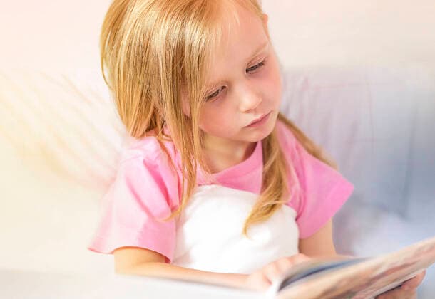 A little girl reads a book before bed in her bed Minsk, Minsk Region, Belarus CR_NARA210628-779813-01 ,model released, Symbolfoto