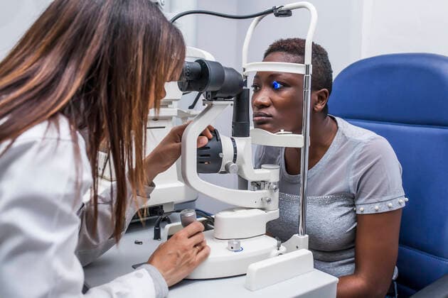 Optometrist adjusting the retinograph during study of the eyesight of a black woman, Model released DavidFuentes_Optometry_32.jpg Copyright: xDavidxFuentesx MR