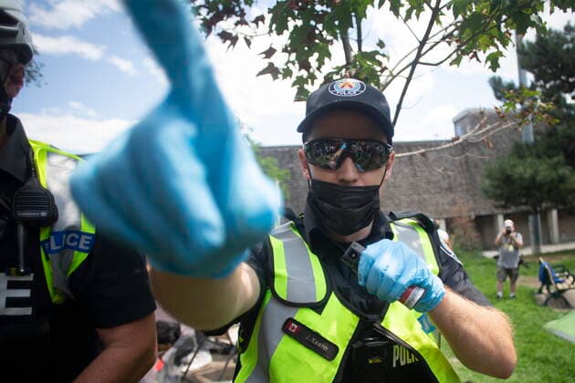 July 21, 2021, Toronto, on, Canada: A Toronto police officer threatens the use of pepper spray as Police and city officials clear the Lamport Stadium Park encampment in Toronto on Wednesday July 21, 2021. The operation came a day after a different encampment was cleared at a downtown park. The city has cited the risk of fires and the need to make parks accessible to everyone as factors behind the clearings. Toronto Canada  - ZUMAc35_ 20210721_zaf_c35_016 Copyright: xChrisxYoungx