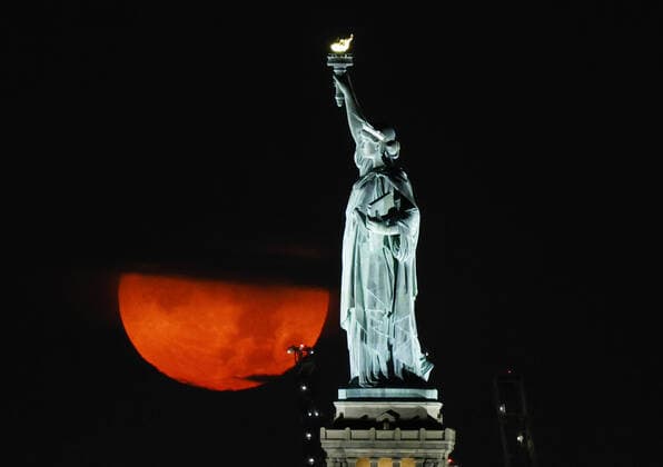 Bilder des Jahres 2021, News 07 Juli News Themen der Woche KW29 News Bilder des Tages A full Buck Moon, partially obstructed by clouds, sets behind the Statue of Liberty in New York City on Friday, July 23, 2021.  NYP20210723101 JohnxAngelillo