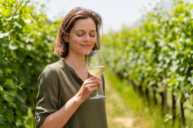 Smiling woman smelling wine while standing at vineyard model released Symbolfoto property released DIGF16131