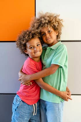 IMAGO Kreativ: Bruderschaft Brothers embracing in front of colorful wall model released Symbolfoto DLTSF02025