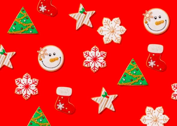 Pattern of various Christmas cookies flat laid against vibrant red background FLMF00574