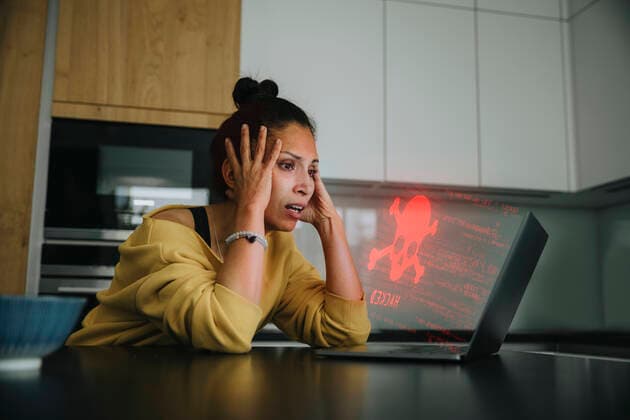 Woman with head in hands looking at danger icon laptop model released Symbolfoto property released LIFIF00047
