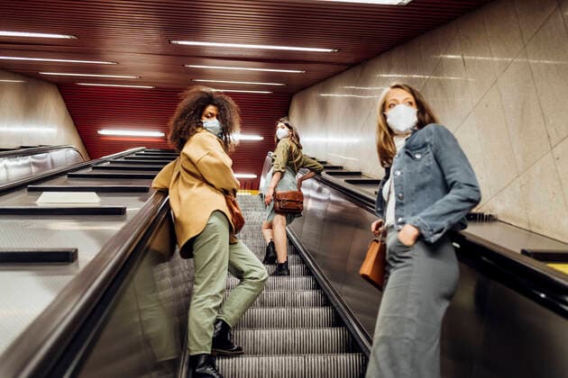 IMAGO Creative: Corporate: Klimaschutz, Digitalisierung und Urbanisierung Friends with protective face mask standing at social distance on escalator model released Symbolfoto MEUF03527