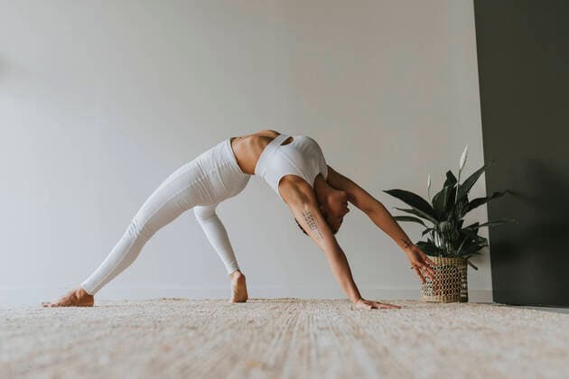 IMAGO Creative: Clickbait, Sport und Fitness Flexible yogi practicing while bending over backwards at yoga studio model released Symbolfoto property released OCAF00657
