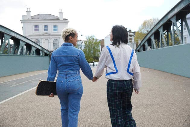IMAGO Creative: Urban Diversity Lesbian couple holding hands while walking on bridge model released Symbolfoto PMF01850