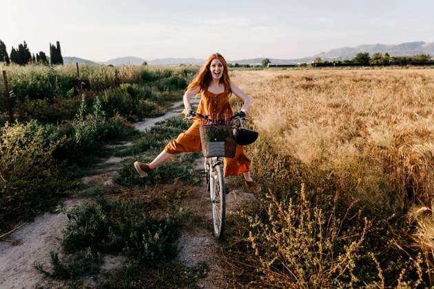 Carefree woman riding bicycle in agricultural field model released Symbolfoto TCEF01965