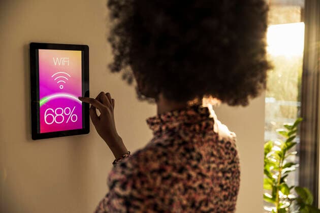 Woman using home automation device on wall model released Symbolfoto property released UUF23539
