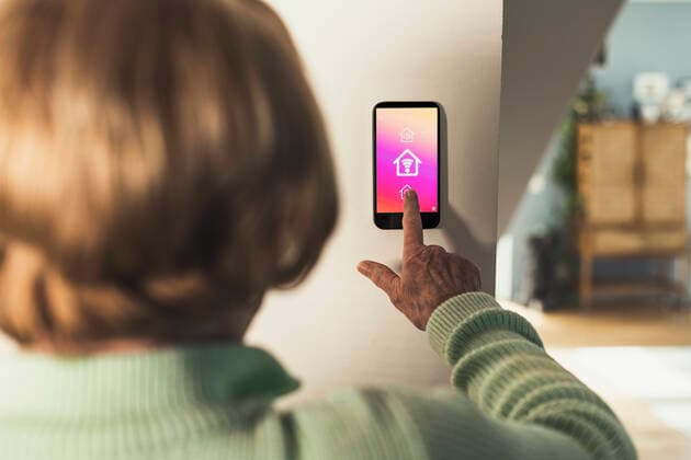 IMAGO Creative: Internationaler Tag der Architektur am 3. Oktober. Thema: Architektur zum Wohlfühlen Woman using futuristic home automation device on wall model released Symbolfoto property released UUF23652